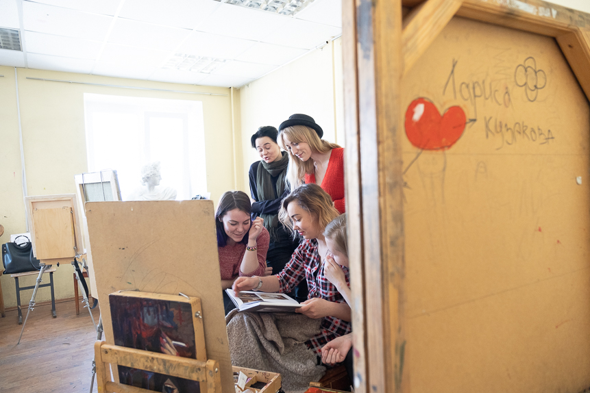 Девочки листают альбом лучших работ студентов Ярославского художественного училища — для вдохновения.